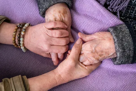 Hände halten die Hände eines älteren Menschen